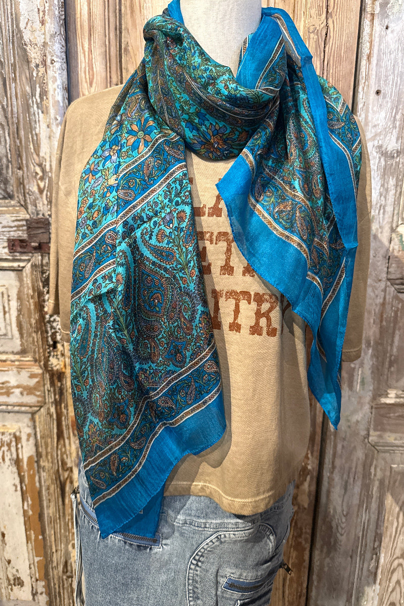Trestles Clothing Company silk boho scarf in vibrant blue with intricate paisley floral patterns on a mannequin